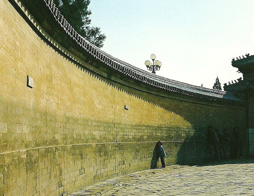 photograph of echo wall at the Temple of Heaven in Beijing; curved wall of greenish ochre hue